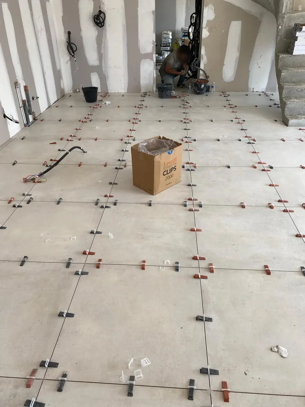 Pose en cours, carreleur au fond de la pièce