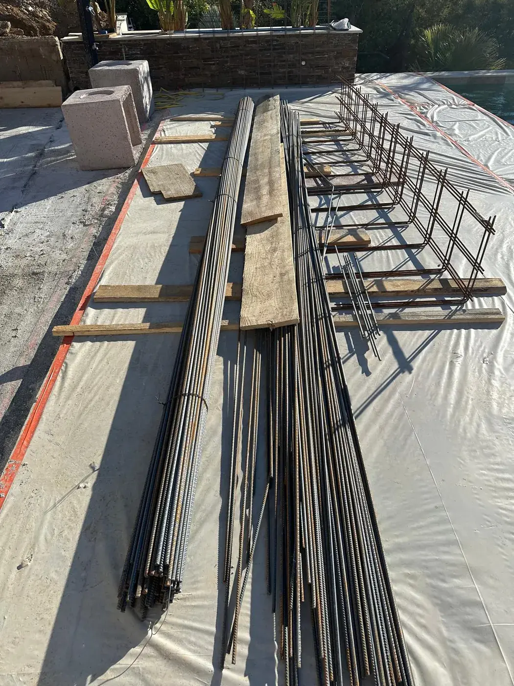 Armatures et poutres en attente sur l'aire de préparation du chantier