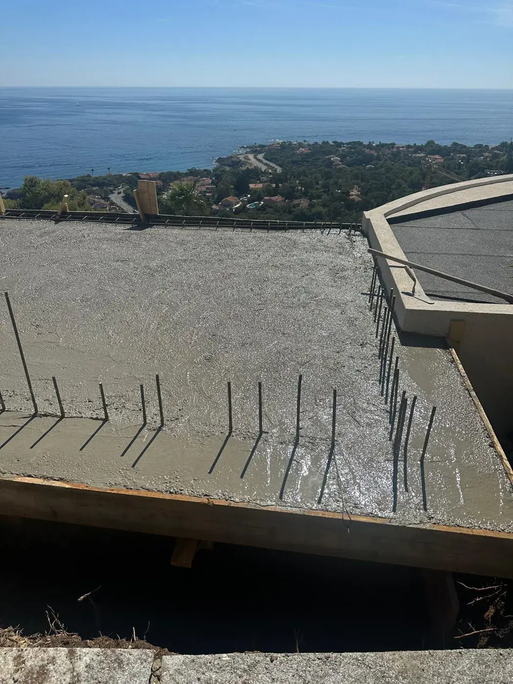 Dalle béton fraîchement coulée en bord de terrasse, vue sur la mer