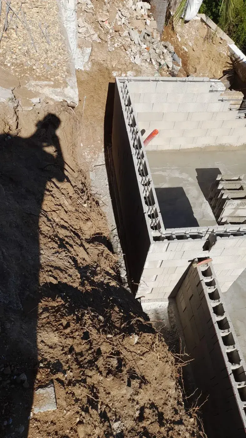 Élévation d'un mur en blocs béton en fond de fouille