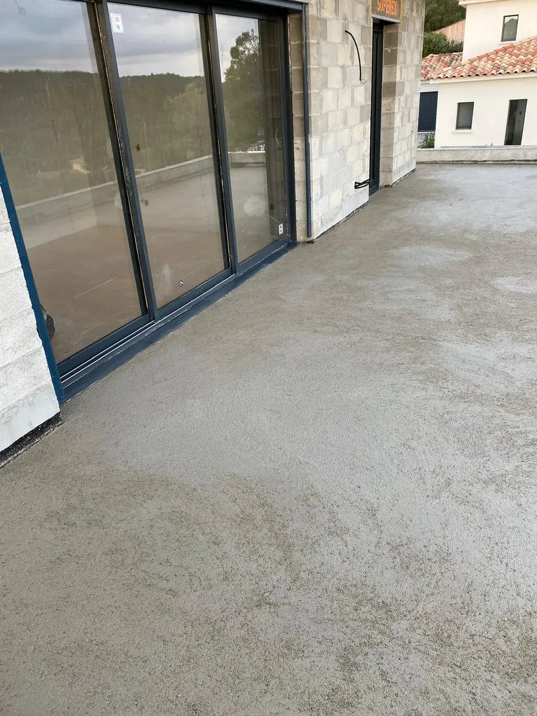 Chape tirée sur la terrasse devant les baies vitrées
