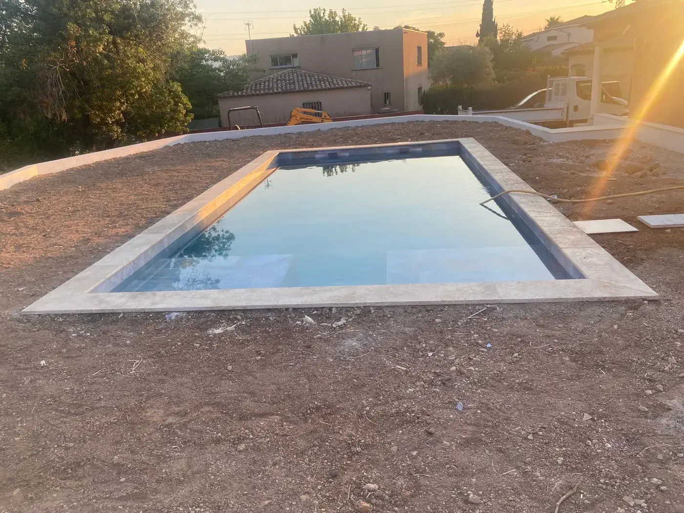 Piscine béton mise en eau au coucher du soleil
