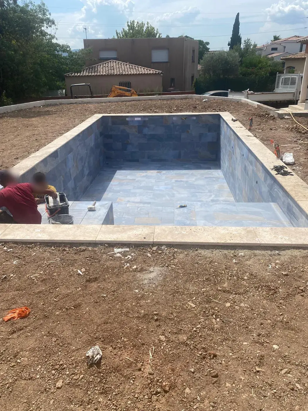 Pose du carrelage dans le bassin béton