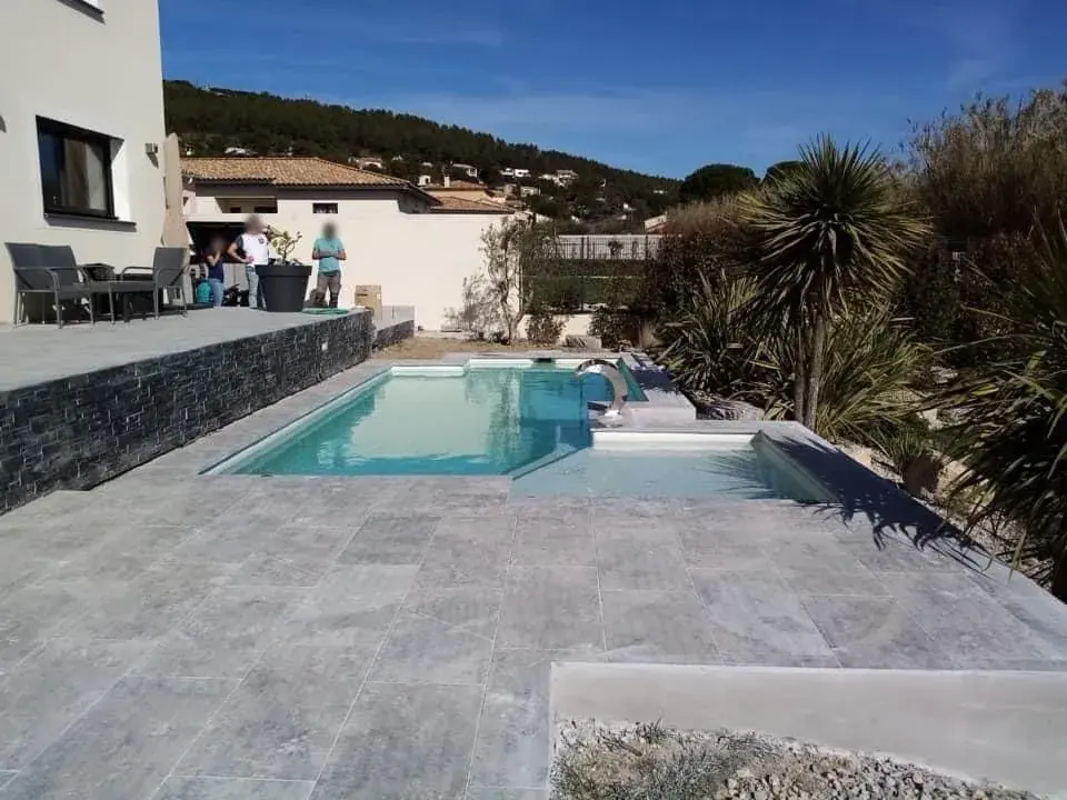 Vue d'ensemble d'une piscine et de sa plage rénovée