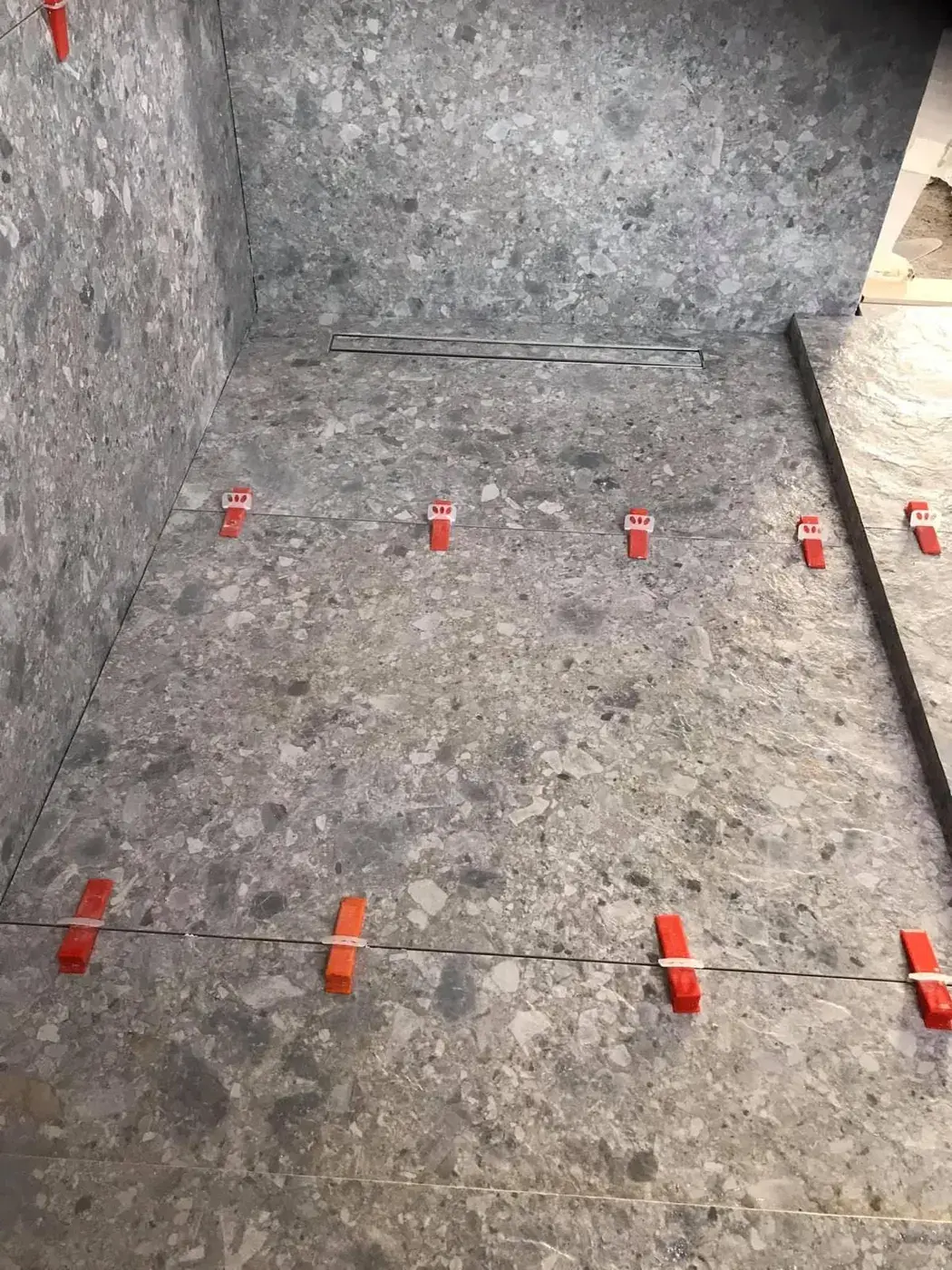 Douche en grand format effet terrazzo avec caniveau linéaire