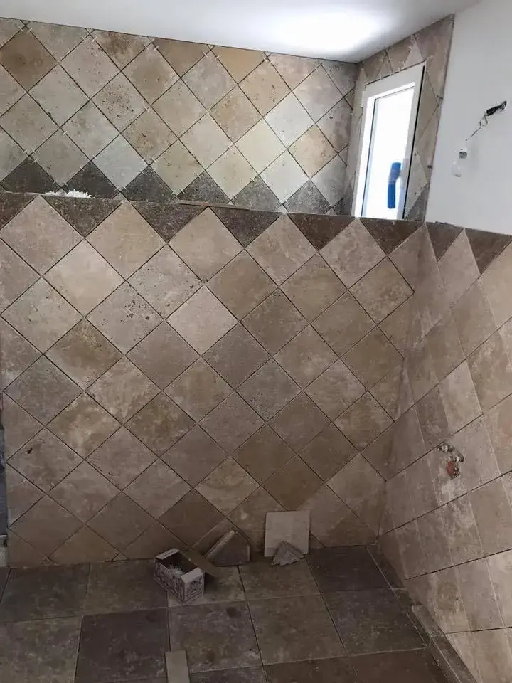 Faïence travertin posée en diagonale dans une salle d'eau