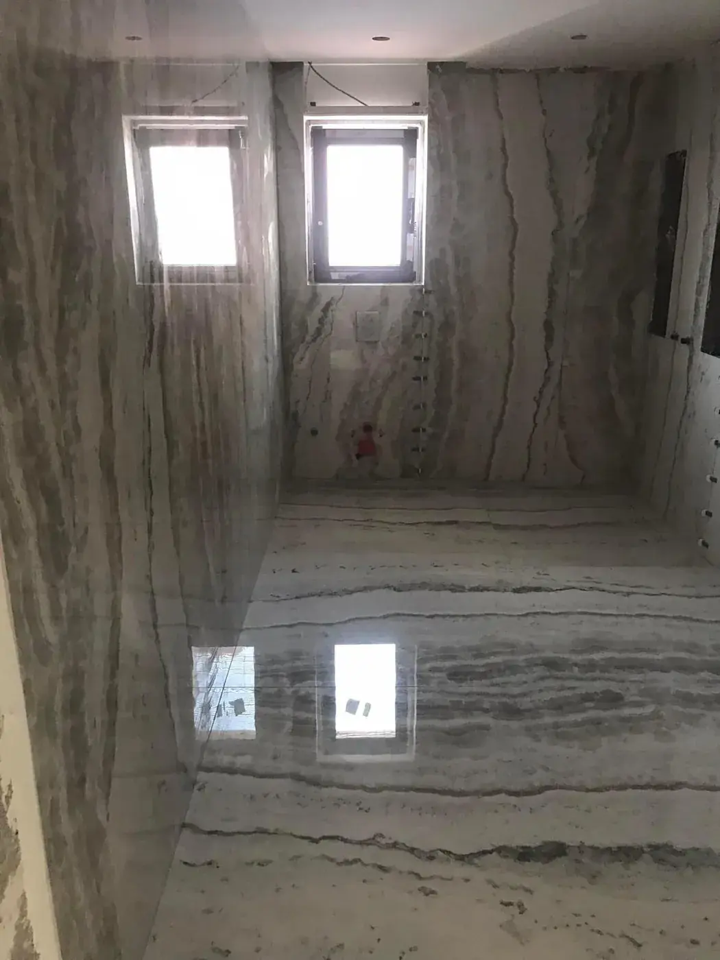 Salle de bain entièrement habillée de grands formats effet marbre