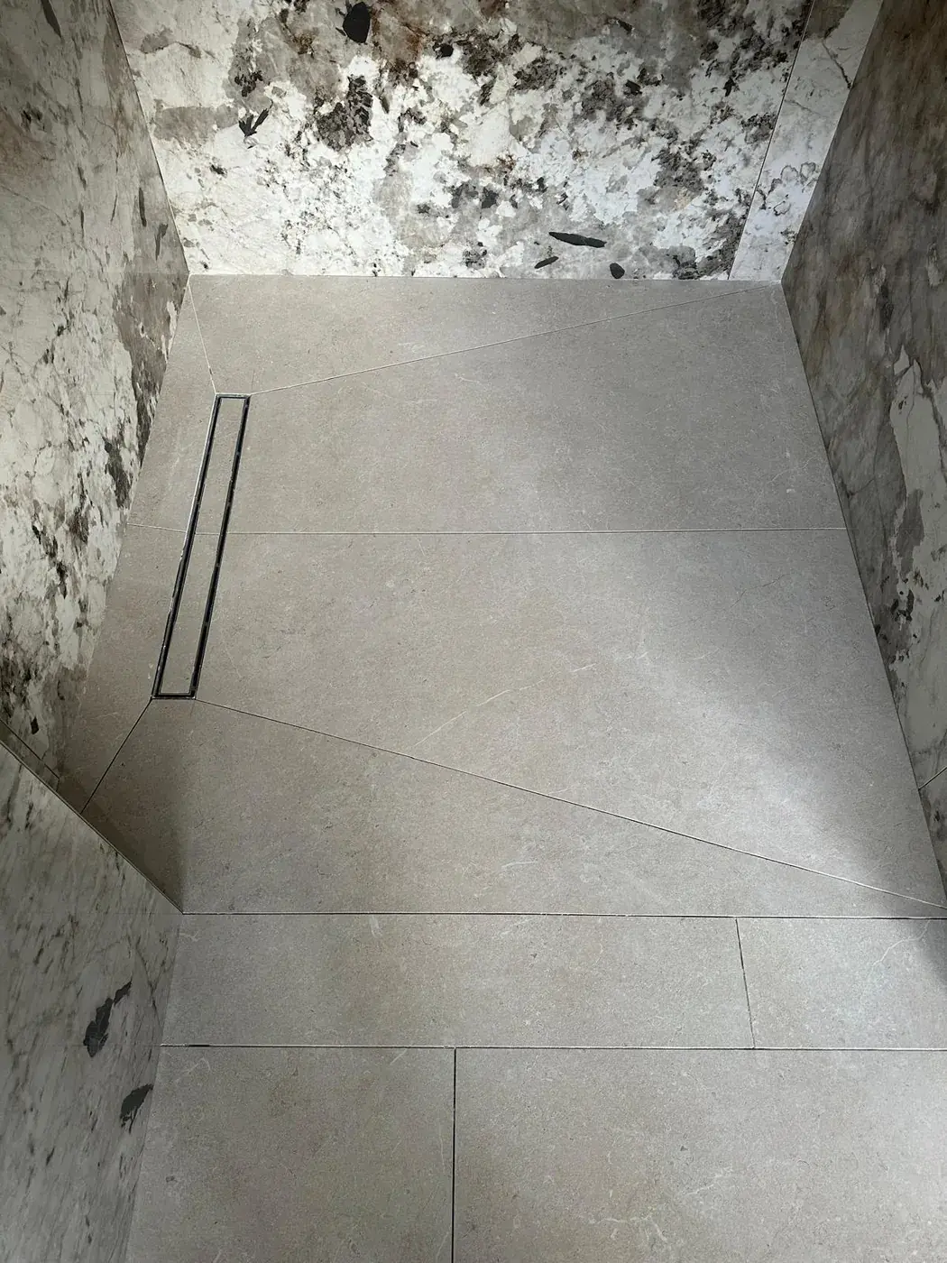Douche à l'italienne avec caniveau linéaire et parois en marbre