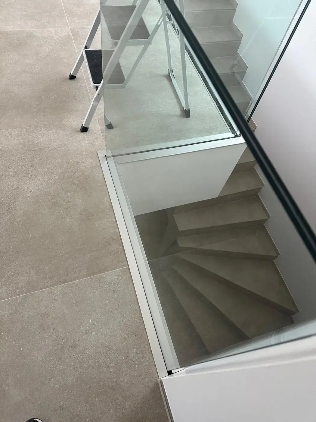 Escalier avec garde-corps vitré vu depuis l'étage