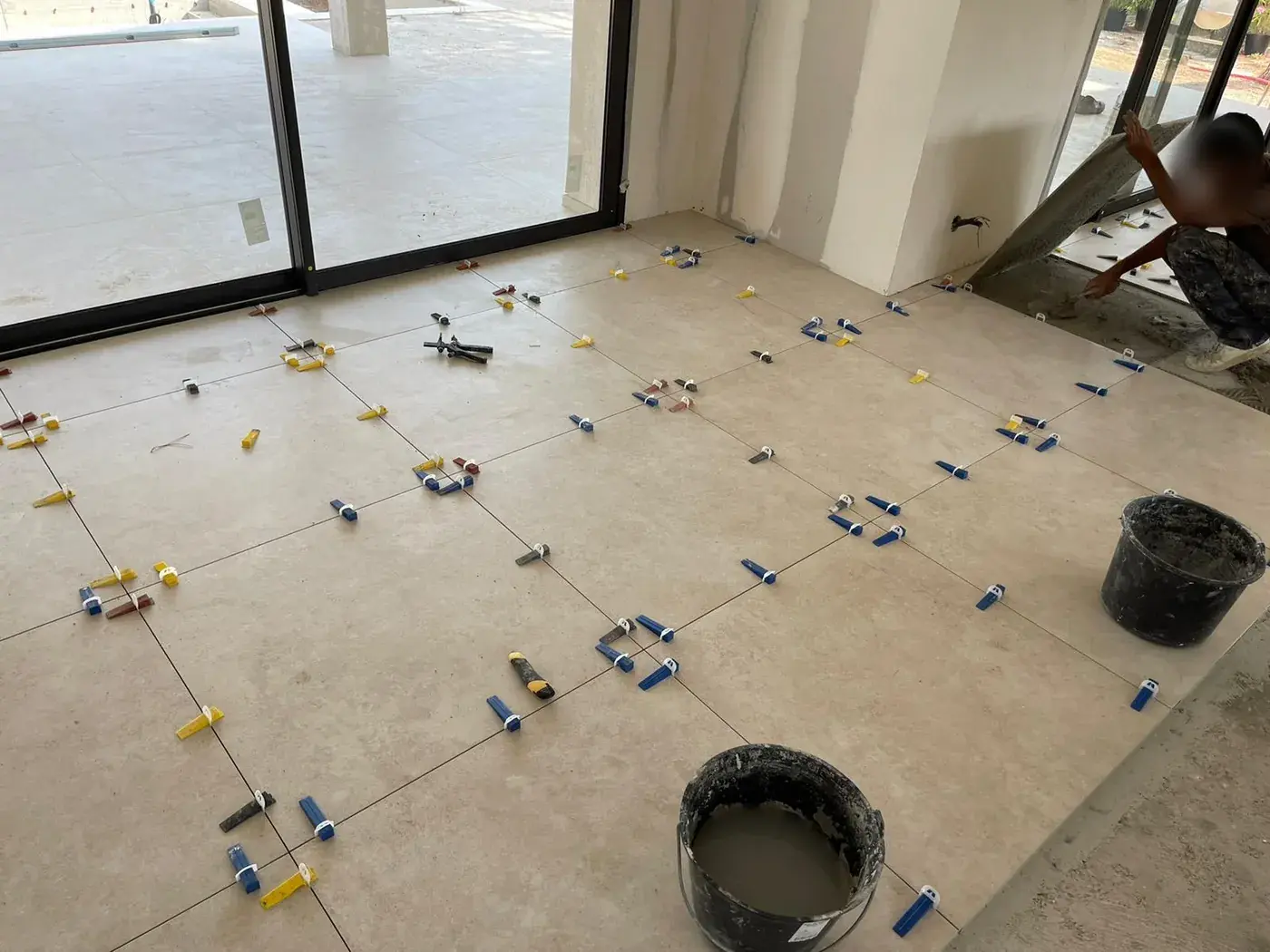 Carrelage grand format en pose devant une baie vitrée