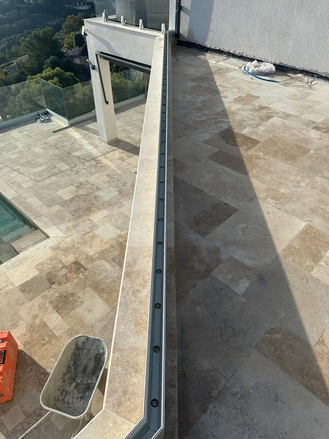 Circulation extérieure en travertin longeant la façade de la villa