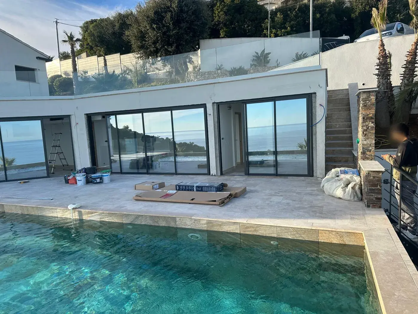 Plage de piscine en travertin bordant une baie vitrée toute hauteur