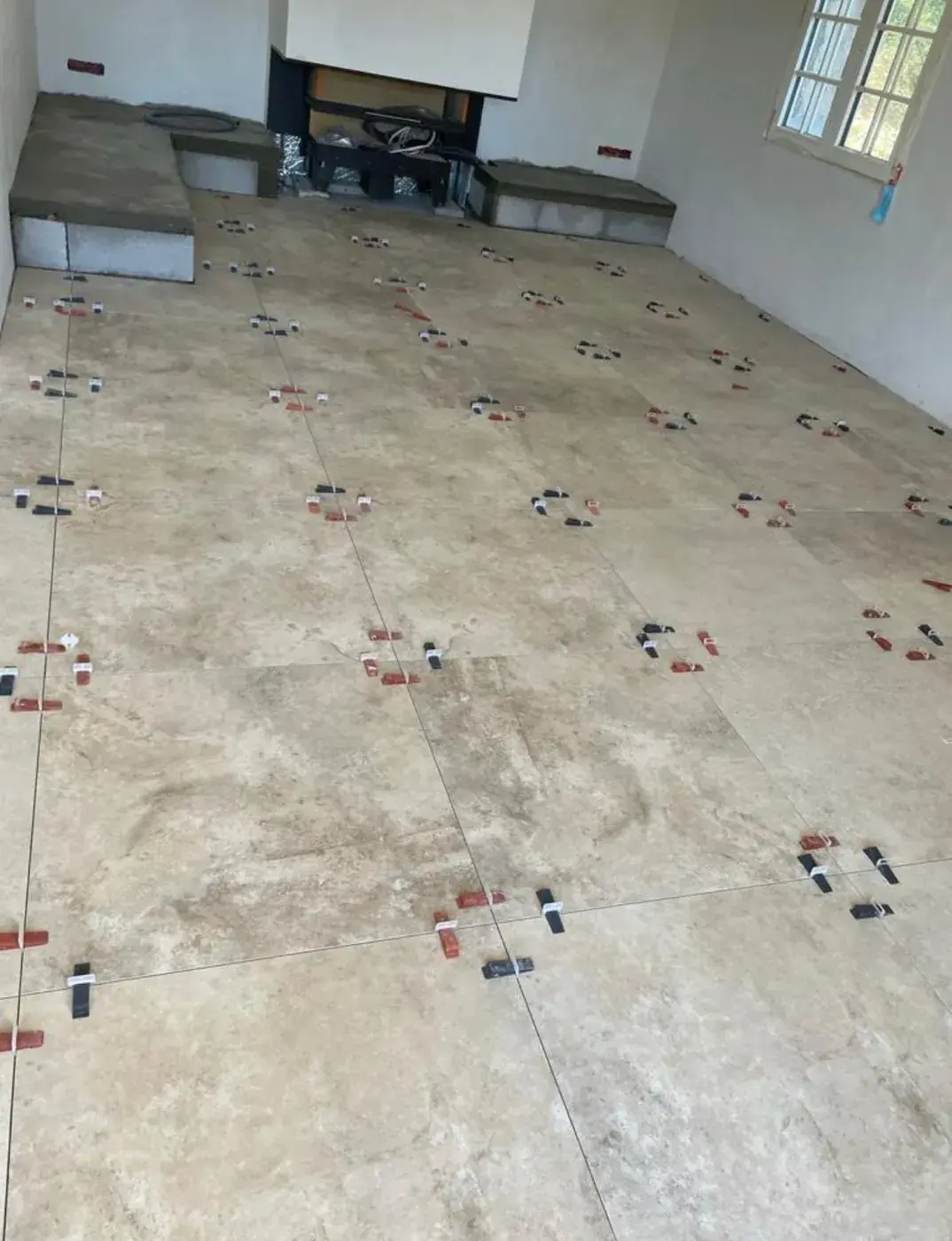 Carrelage effet travertin en pose devant la cheminée