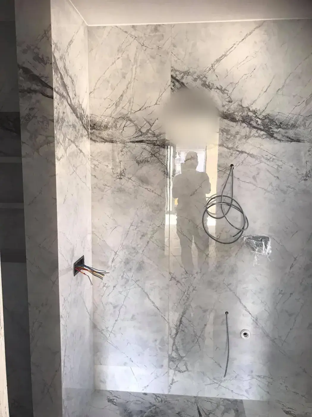 Douche habillée de grandes plaques effet marbre blanc