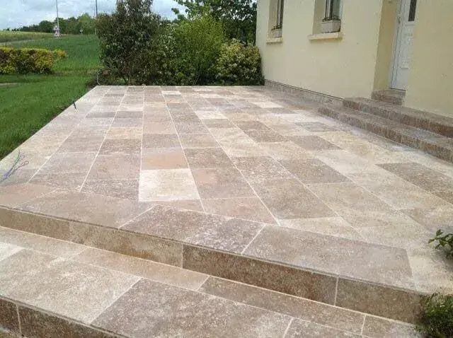 Terrasse en travertin et emmarchement devant une maison