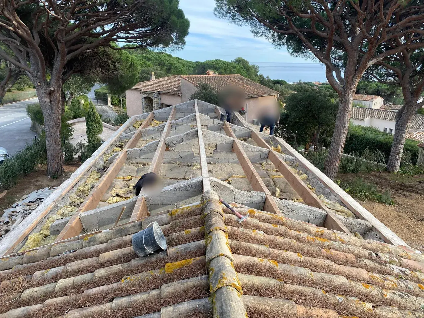 Toiture déposée jusqu'aux liteaux, vue sur la mer au loin